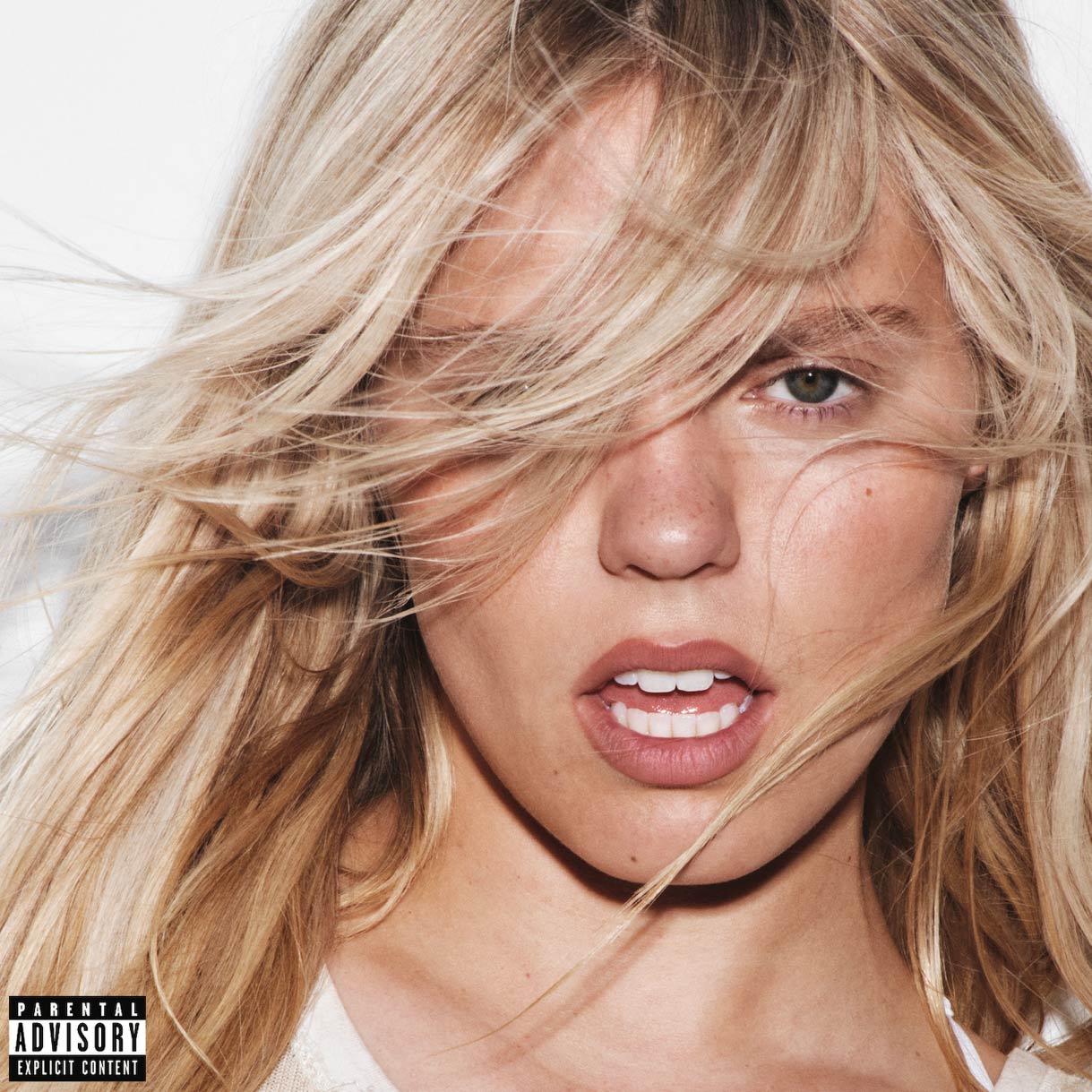 Close-up photo of Reneé Rapp with tousled blonde hair partially covering her face, lips slightly parted, and a bold, intense expression. The image features a clean white background and a "Parental Advisory: Explicit Content" label in the bottom left corner.