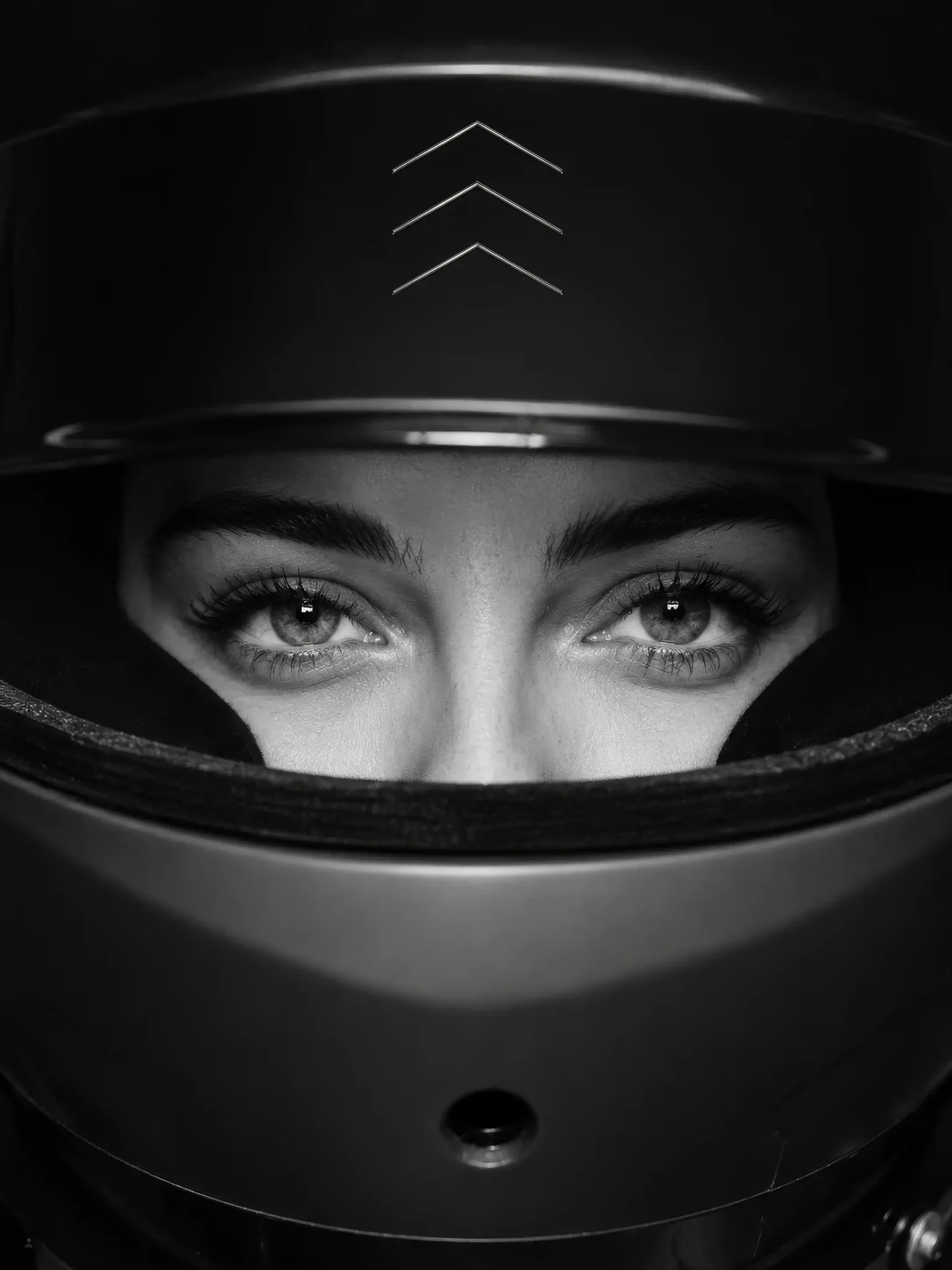 Woman in a racing helmet with The Formation logo, close-up black and white portrait